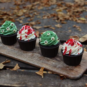 Halloween-Cupcake-Box von Malina Stories mit 4 handdekorierten Schokoladen-Cupcakes, gefüllt mit fruchtigem Himbeerkompott und verfeinert mit Vanille-Buttercreme in zwei gruseligen Halloween-Designs.